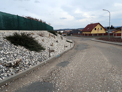 Komunikace v ulici Pod Kuřidlem směrem k ulici Švandy dudáka. Po levé straně zabraný městský pozemek majitelkou sousední nemovitosti formou výpůjčky městských pozemků na dobu neurčitou bez možnosti výpovědi. Dostanou-li se navíc kameny až do silnice, mohou klidně i vážně poškodit projíždějící automobily.